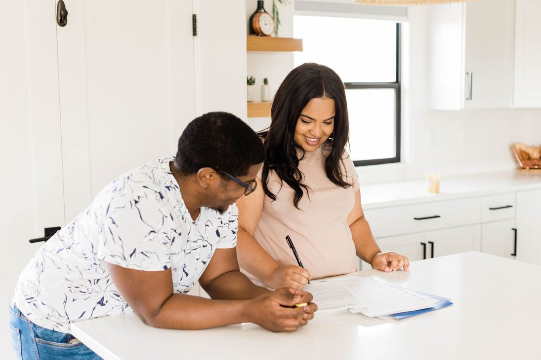 Happy Couple Signing Paperwork for New Home